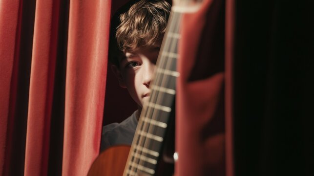A close-up of a boy sneeping behind the curtain, ready to get on stage