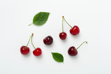 Fresh cherries in bowl on concrete background, top view