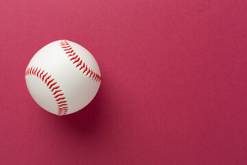 Baseball ball on color background, top view