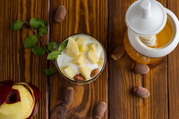 sweet homemade yogurt in a glass with apples, nuts and honey