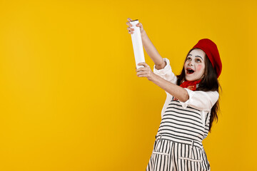 Happy girl dressed like mime with confetti popper on yellow background, space for text. Surprise...