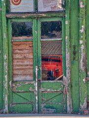 Reflection of an old red truck in the window of an old store front in a town in the Palouse.