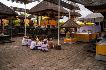 Balinese Temple Ceremony with Offerings and Devotees in Traditional Attire