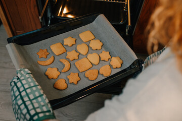 Baker taking freshly baked cookies out of oven