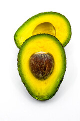 Close up of a ripe avocado cut in half isolated on a plain white background.