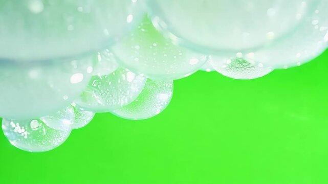Thick patches of bubbles create a fluffy cloudlike appearance in contrast with green. Green screen chromakey