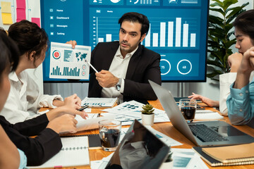 Diverse group of business analyst team analyzing financial data report. Finance data analysis chart and graph dashboard show on TV screen in meeting room for strategic marketing planning. Habiliment