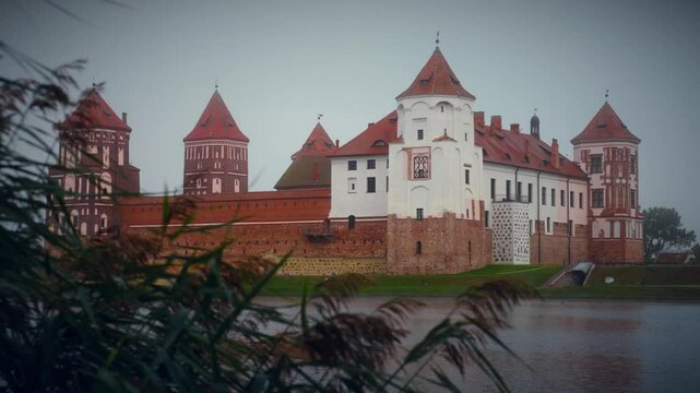 Historic mir castle reflecting in misty lake