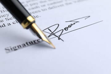 Fountain pen leaving signature on contract, closeup