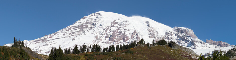 Washington State, Mount Rainier National Park. Panorama view of Mount Rainier with a covering of new snow in autumn, high elevation blowing snow