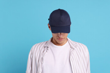 Man in stylish baseball cap on light blue background. Mockup for design
