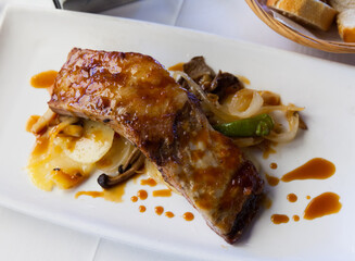 Delicious grilled pork ribs in teriyaki sauce with baked potatoes and mushrooms