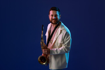 Professional musician with saxophone on blue background