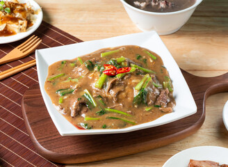 Beef Risotto topped with red chili served in plate with fork and chopsticks isolated on wooden board side view of taiwan food