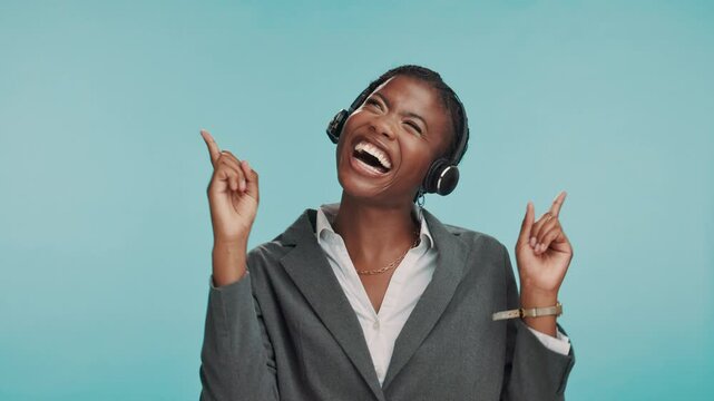 Pointing up, headset and excited black woman in studio with promotion, offer or opportunity. Announcement, contact us and happy call center businesswoman showing presentation space on blue background