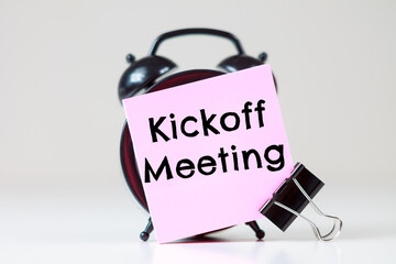 Kickoff Meeting text on a sticker for reminders with an alarm clock