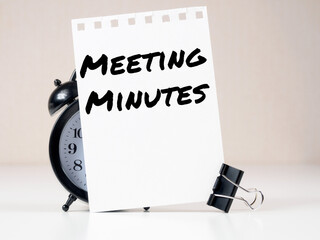Meeting Minutes header on white note paper background alarm clock