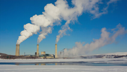 Industrial facility emitting smoke over a vast snowy landscape.