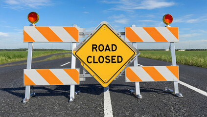 Road closed with a yellow sign and striped barriers flashing warning lights.