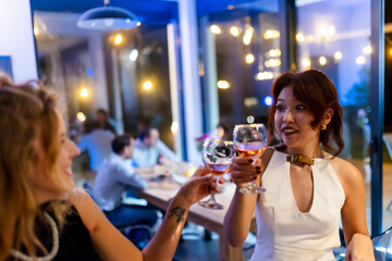 Friends enjoying a social evening while toasting with wine in a modern restaurant setting