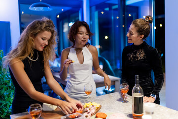 Friends enjoying an evening social gathering with wine and snacks indoors