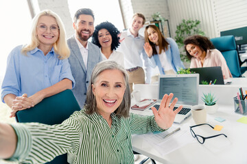 Friendly office team taking a selfie to capture a moment of corporate camaraderie and teamwork