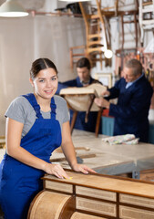 Woman restorer carefully and carefully restores chest of drawers in a restoration workshop