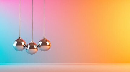 Three shiny metallic pendulums hanging against a colorful background, showcasing a contemporary vibe and artistic design that complements any modern setting.