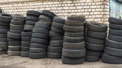 Storage of discarded old car tires outdoors, showcasing a pile of used tires ready for recycling....