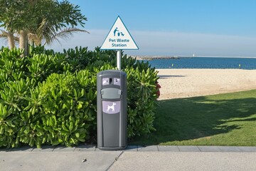 Pet waste station on dog friendly public beach. Pet waste cleanup. Bin for dog owner cleanup dog excrement. Dog poop container. Hygienic pet poop solution. Dubai,UAE