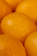 a large number of ripe orange tomatoes that are on the table