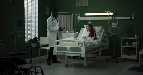 Doctor enters the room with a tablet, ready to review the patient's progress.