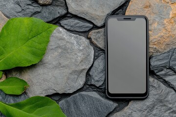Mobile Phone on Textured Stone Surface Surrounded by Green Leaves in Natural Setting