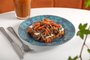 Delicious and healthy breakfast. Mushroom toast and green juice on a restaurant table.