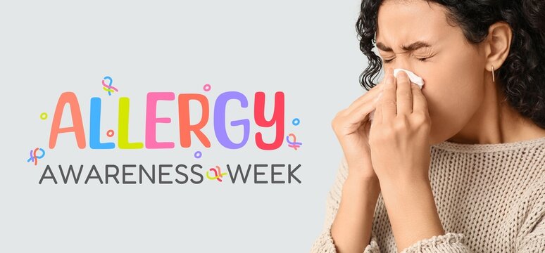 Banner for Allergy Awareness Week with young African-American woman blowing nose - Powered by Adobe