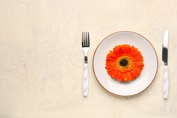 Table setting with beautiful gerbera flower on beige grunge background