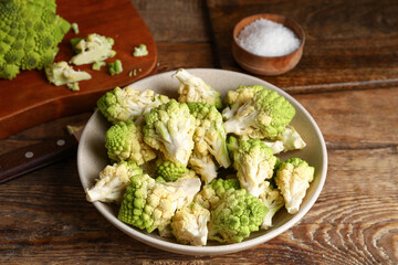 Bowl with baby romanesco cabbage on wooden table