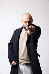 Mature bald man with beard pointing on you. Vertical.