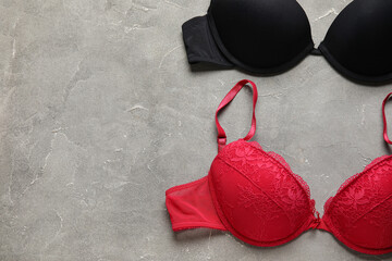 Stylish female bras on grunge background