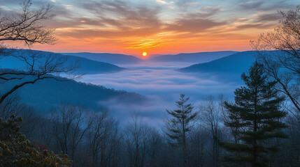 Obraz premium Landscape of the sunset over the foggy and cloudy mountain range.