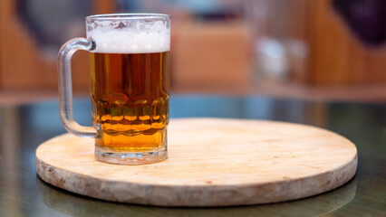 Cerveza con espuma aislada en tabla de madera