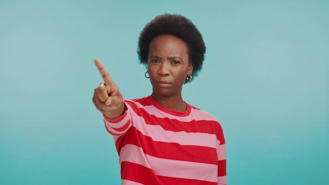 No, gesture and face of black woman in studio with anger, disappointment and advice in caution. Compliance, warning and frustrated person with stop hand sign for wrong decision on blue background