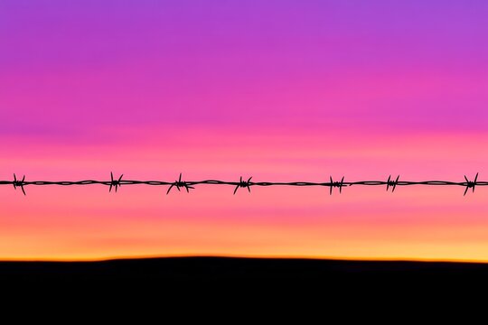 Wire fence with a purple sky in the background