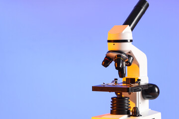 Modern microscope on blue background