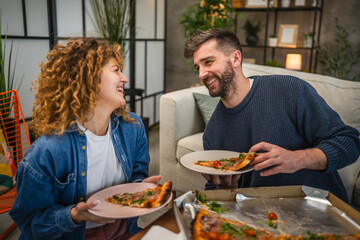 husband and wife eat pizza at home having time together with food
