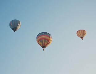 Fototapeta premium Colorful Hot Air Balloons Soaring Gracefully Across a Clear Blue Sky During a Sunny Day