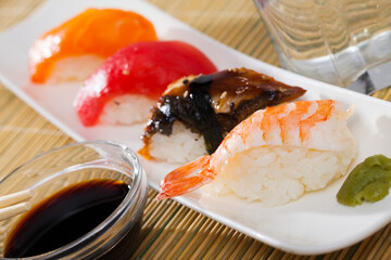 Traditional Japanese cuisine. Nigiri with fresh salmon, tuna, eel and shrimp served with soy sauce and wasabi