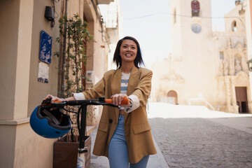 Asian woman enjoying in town with e scooter