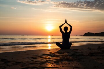 Silhouette of women do a yoga on the beach at sunset