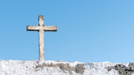 Weathered cross atop salt flat, clear sky. Religious backdrop